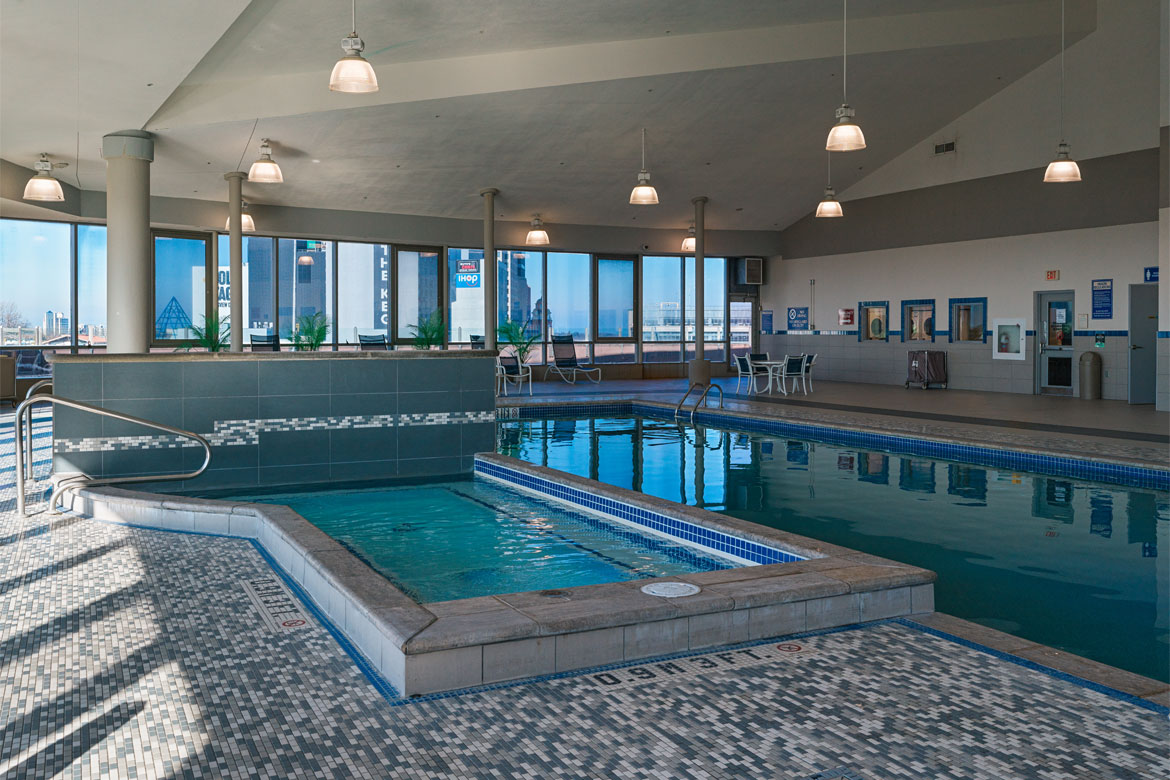 A serene indoor pool surrounded by comfortable seating and natural light streaming in from expansive windows.