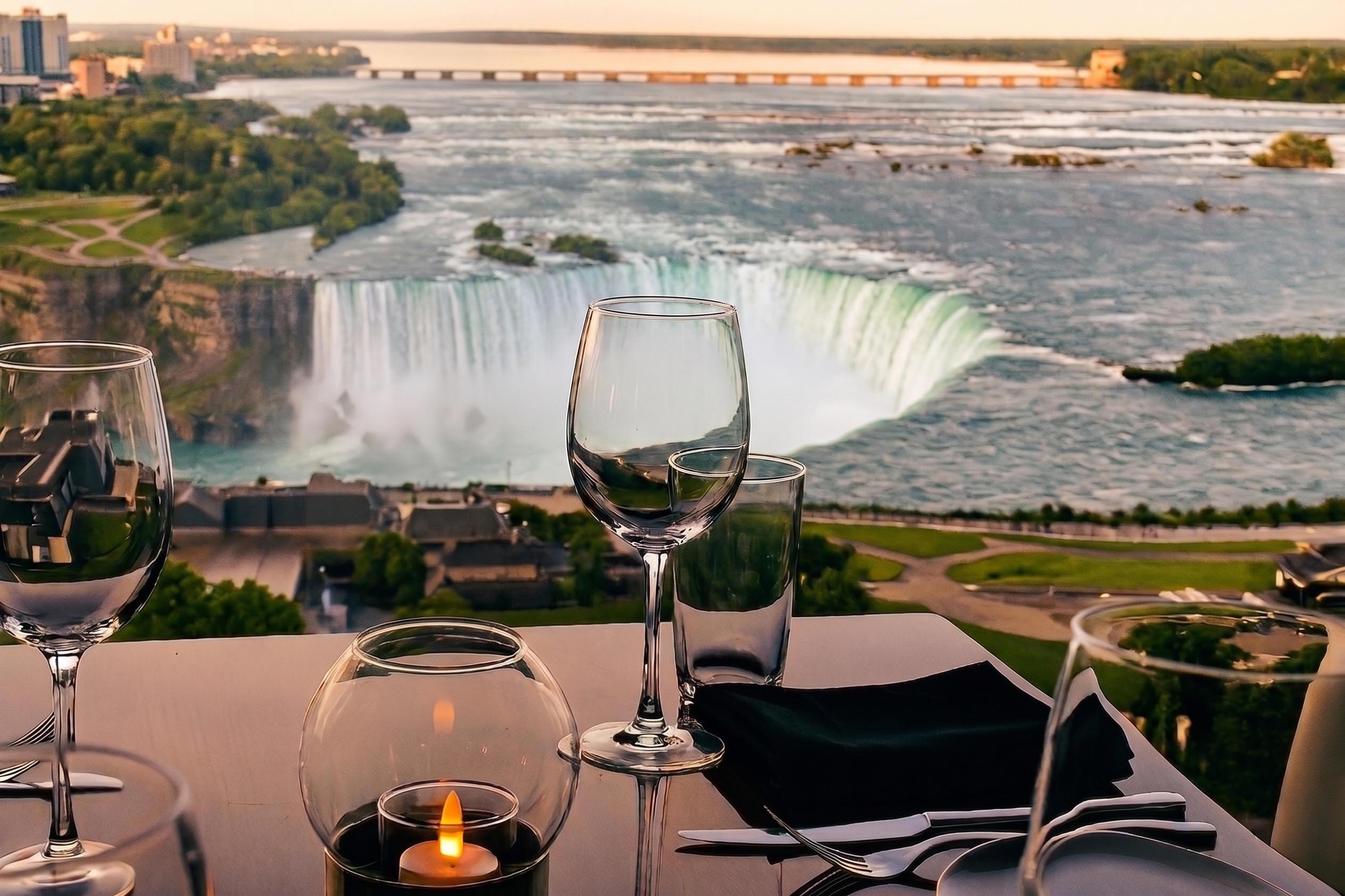 A stylish restaurant table with steak, broccoli, seafood, red wine, and people chatting in the background.