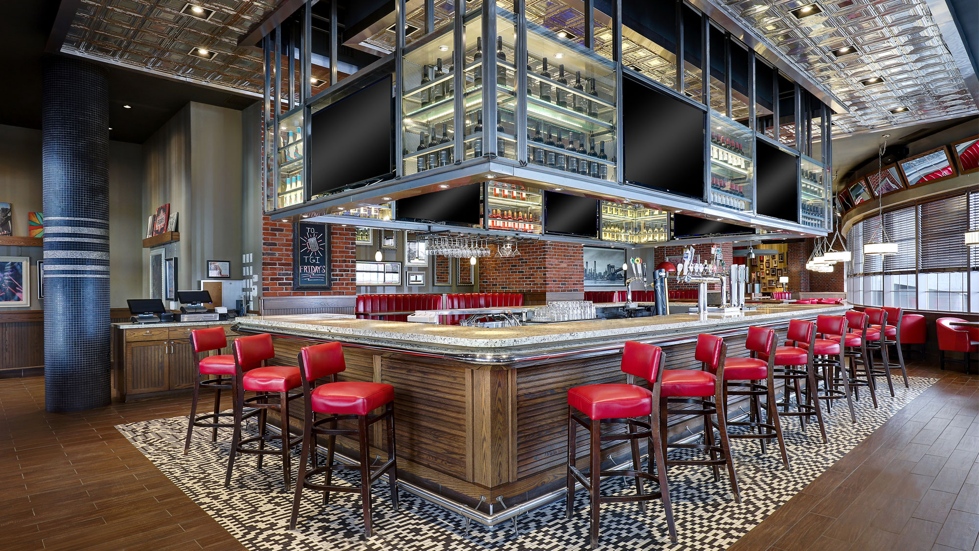 Modern restaurant interior with white tables, gray chairs, and a prominent bar area.
